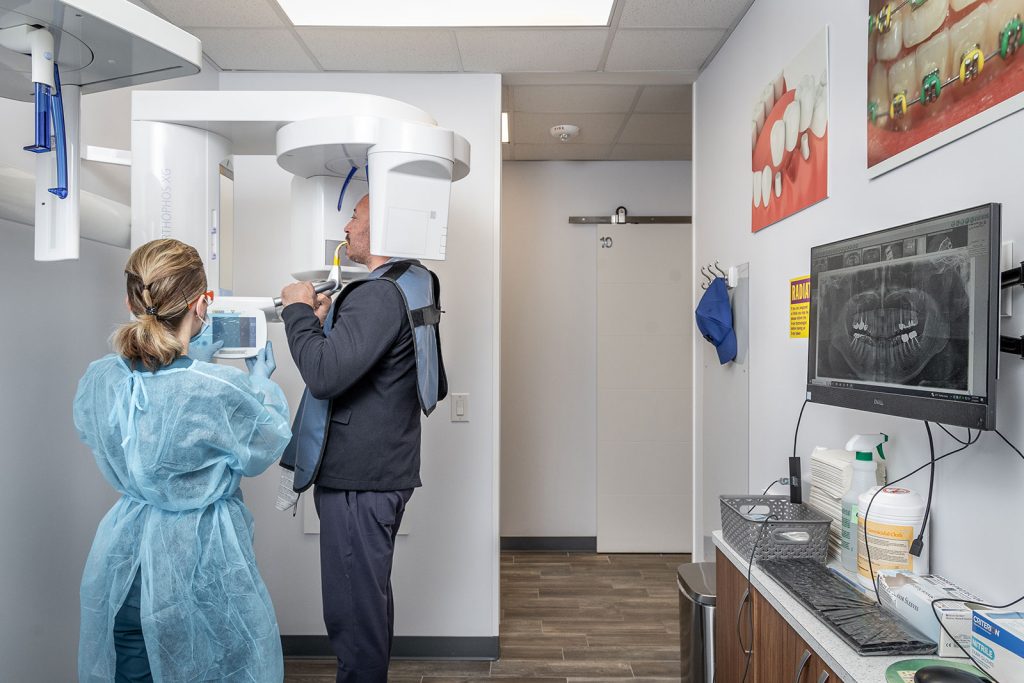 Dentist examining patient's teeth via dental 3D scanner